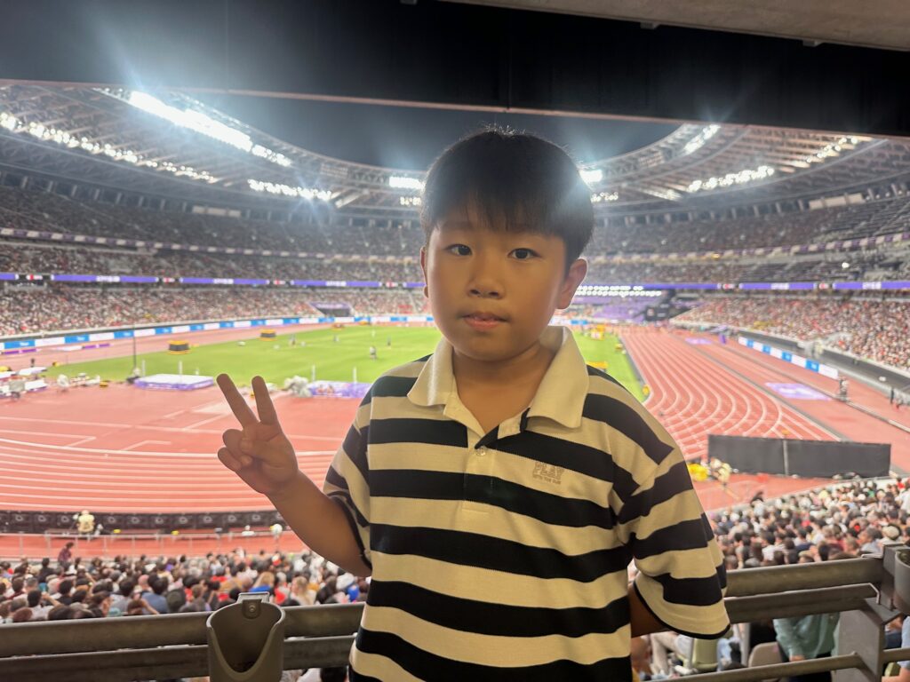 スタジアムで真剣に陸上観戦をする息子