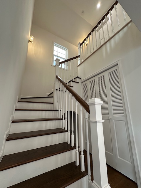 リビング中央に配置された開放的な吹き抜けと美しい輸入階段