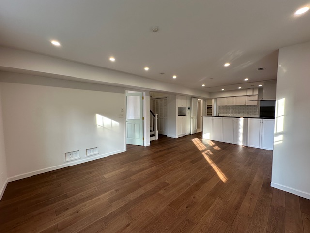 濃い目の床材とドライウォール仕上げが美しいリビングルーム